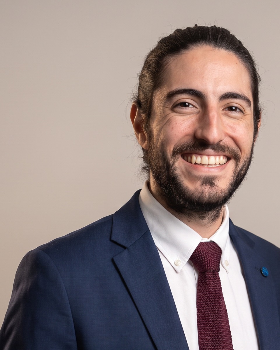 Alejo Pijuan in a navy suit and burgundy tie